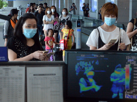 중동호흡기증후군(메르스) 환자가 18명으로 늘어난 1일 인천공항을 통해 입국하는 관광객들이 마스크를 쓴채 발열검사대를 통과하고 있다. 박지환 기자 popocar@seoul.co.kr