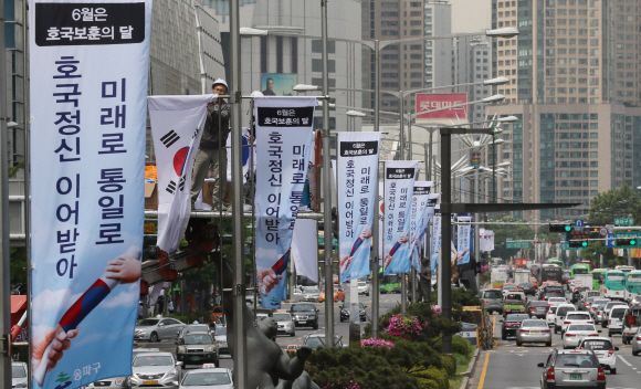 1일 오전 서울 송파구 올림픽로 일대에서 송파구청 관계자가 태극기와 호국보훈의 달 배너기를 설치하고 있다. 2015. 06. 01 이언탁 utl@seoul.co.kr