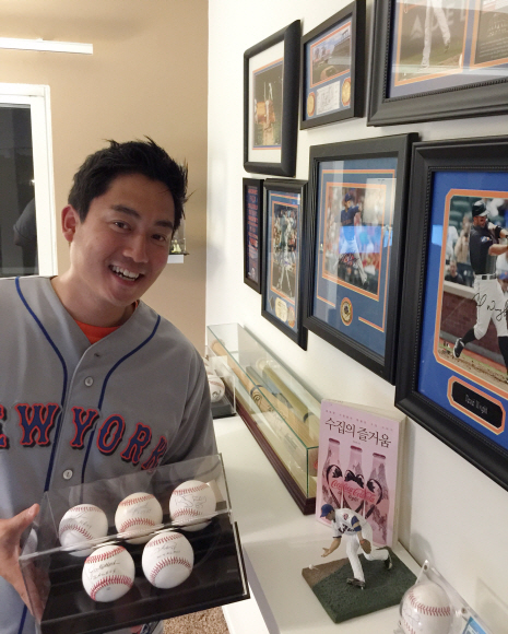 메이저리그 수집가 토니 김이 미국 로스앤젤레스 신혼집에 마련한 자신의 컬렉션을 배경으로 자신이 사랑하는 뉴욕 메츠 선수들의 사인이 담긴 야구공 박스를 들어 보이며 웃고 있다. 토니 김 제공