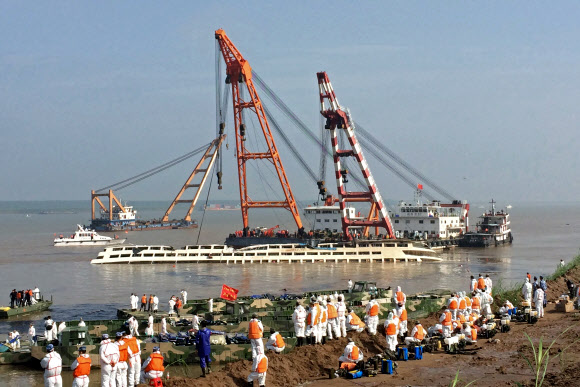 5일(현지시간) 중국 후베이성 젠리현 양쯔강에 침몰한 유람선 ‘동방의 별(Eastern Star)’을 크레인선을 동원해 인양하고 있다. ⓒ AFPBBNews=News1