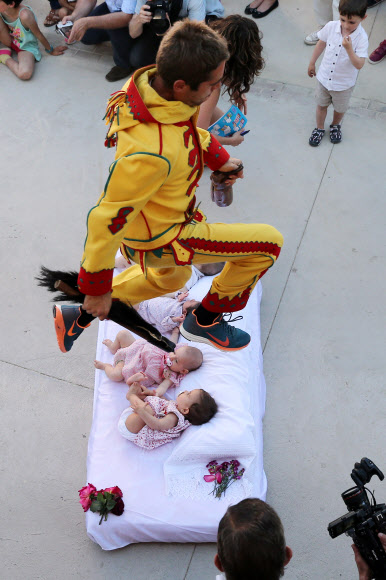 7일(현지시간) 스페인 북부 부르고스(Burgos) 인근 카스드릴로 드 무르시아(Castrillo de Murcia) 마을에서 ‘엘 콜라초(El Colacho)’가 축제가 열려 악마 분장을 한 남성이 매트리스에 누워있는 아기들 위로 뛰어넘고 있다.  ⓒ AFPBBNews=News1