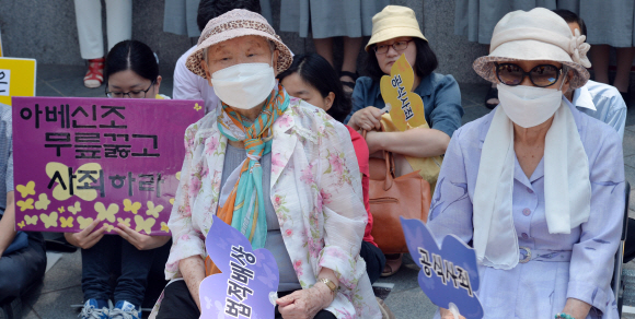 10일 서울 종로구 주한일본대사관 앞에서 열린 일본군 위안부 문제 해결을 위한 1182차 정기 수요집회에서 길원옥 할머니(왼쪽)와 김복동 할머니가 마스크를 쓴 채 사회자의 발언을 듣고 있다.  손형준 기자 boltagoo@seoul.co.kr