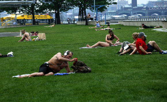 뉴욕 맨해튼 기온이 상승하자 사람들이 11일(현지시간) 허드슨 강가에서 일광욕을 즐기고 있다. ⓒ AFPBBNews=News1