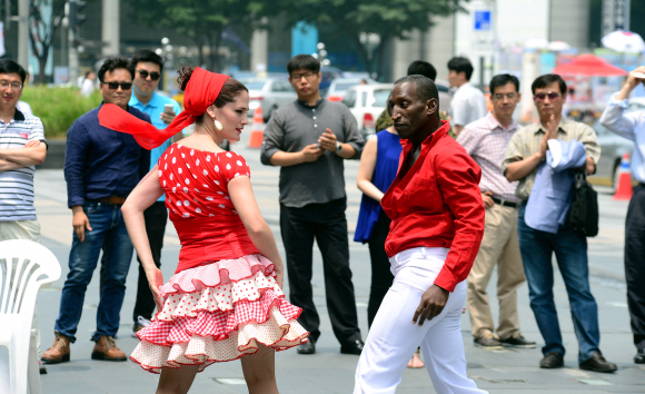 24일 오전 청계광장에서 2015 쿠바문화예술축제 <누에보 쿠바 재즈 콘서트>에 초청된 예술단의 게릴라거리공연에서 ’마성의 여인’이라는 애칭으로 불리는 쿠바 대표 무용수 Ana Rosa Menses가 정열의 재즈리듬에 맞취 남자파트너와 춤을 추고 있다.  강성남 선임기자 snk@seoul.co.kr