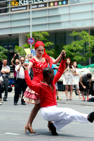 24일 오전 청계광장에서 2015 쿠바문화예술축제 <누에보 쿠바 재즈 콘서트>에 초청된 예술단의 게릴라거리공연에서 ’마성의 여인’이라는 애칭으로 불리는 쿠바 대표 무용수 Ana Rosa Menses가 정열의 재즈리듬에 맞취 남자파트너와 춤을 추고 있다.  강성남 선임기자 snk@seoul.co.kr