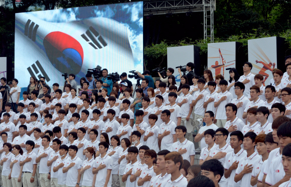 25일 서울 올림픽공원에서 열린 2015 광주하계유니버시아드대회 대한민국 선수단 결단식에 참석한 선수들이 국기에 대한 경례를 하고 있다. 박지환 기자 popocar@seoul.co.kr