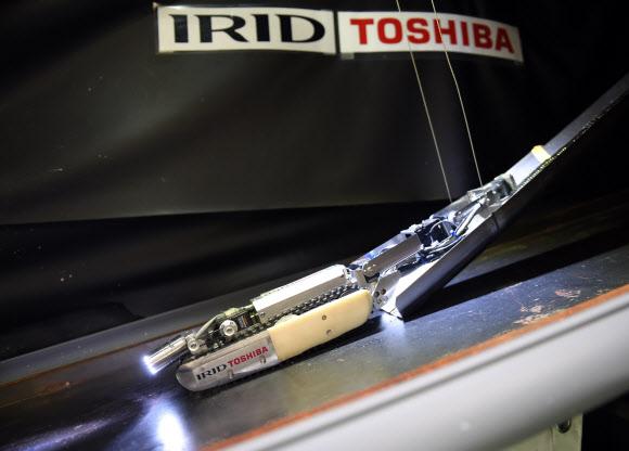 도시바와 IRID(International Research Institute for nuclear Decommissioning)가 개발한 소형 로봇을 30일(현지시간) 일본 요코하마의 도시바 공장에서 언론에 공개했다. 54센티미터 길이, 9센티미터 높이에 두 개의 CCD 카메라를 장착한 로봇은 원자로 격납 용기(PCV)를 조사하기 위해 제작됐다. ⓒ AFPBBNews=News1