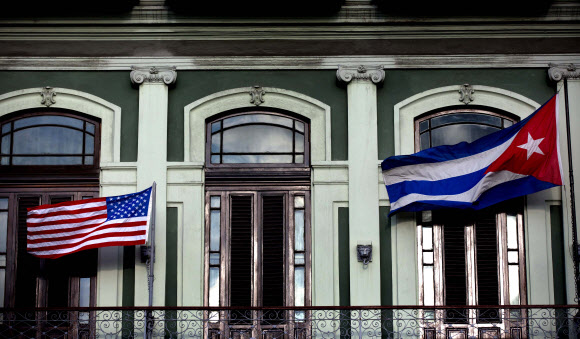 관계 정상화 선언 6개월 만에 미국과 쿠바가 1일 대사관 재개설에 합의했다. 사진은 미국의 쿠바 여행 제한 완화 조치를 축하하고자 지난 1월 쿠바 아바나의 사라토가 호텔에 미국기(왼쪽)와 쿠바기가 나란히 내걸린 모습.  아바나 AP 연합뉴스