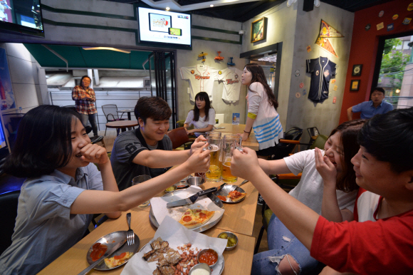 서울 마포구 상수동에 위치한 야구전문 호프집 더그아웃을 찾은 시민들이 야구를 보면서 술을 마시고 있다.   박지환 기자  popocar@seoul.co.kr