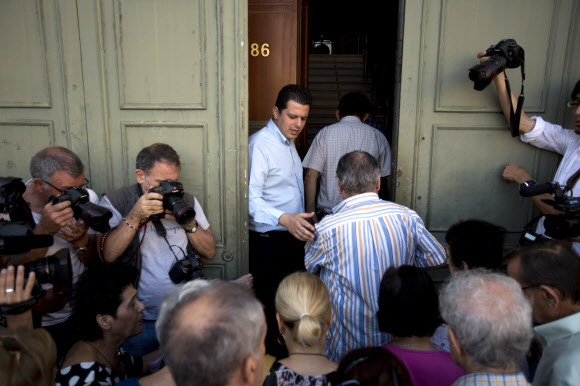 그리스 은행들이 오는 13일까지 영업중단 가능성이 제기된 7일 아테네의 한 은행 앞에서 직원이 현금을 찾으려는 연금 수령자들을 한 명씩 차례로 들이고 있다. 이들은 최대 120유로(약 15만원)를 인출할 수 있다. 아테네 AP 연합뉴스 