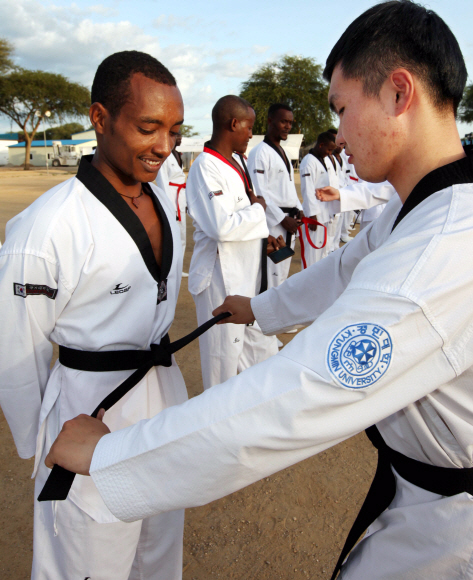 태권도 사범인 서민욱 중위가 8일(현지시간) 남수단 보르 한빛부대 연병장에서 UN에 파병된 에티오피아, 우간다, 인도, 과테말라 등 18명의 군인들에게 검은띠를 수여한 뒤 매주고있다.  사진공동취재단