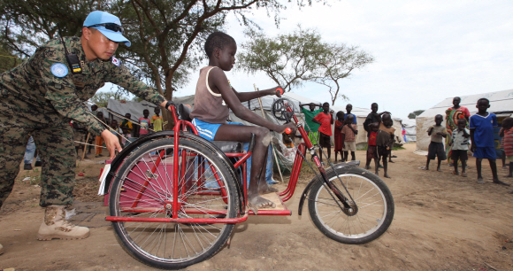 9일 (현지시간) 남수단 보르시의 전쟁 난민 2300여명이 모여있는 POC(Protection of Civilion)에서 한빛부대에서 기증한 휠체어를 한 대원이 밀어주고있다.  2015. 07. 09 사진공동취재단