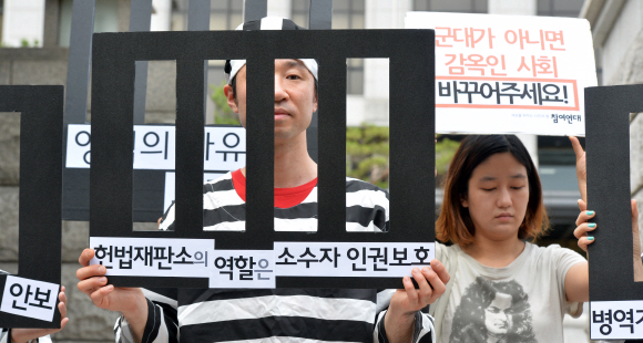 ‘양심적 병역거부자’를 처벌하도록 한 병역법 관련 여론 수렴을 위한 헌법재판소 공개변론이 열리는 9일 서울 종로구 헌재 앞에서 국제엠네스티 등 시민단체 회원들이 죄수복을 입은 채 기자회견을 하고 있다. 이들은 ‘병역 거부자를 처벌하는 현행 병역법은 위헌’이라며 ‘양심의 자유를 보장하라’고 주장했다. 2015. 7. 9 손형준 boltagoo@seoul.co.kr