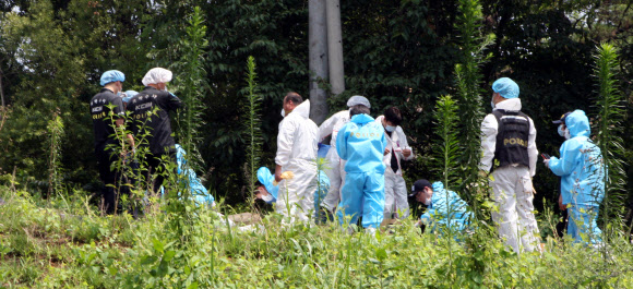 15일 경찰이 A(22·여)씨의 시신이 발견된 경기도 평택시의 한 저수지 인근 야산을 현장 감식하고 있다.  연합뉴스