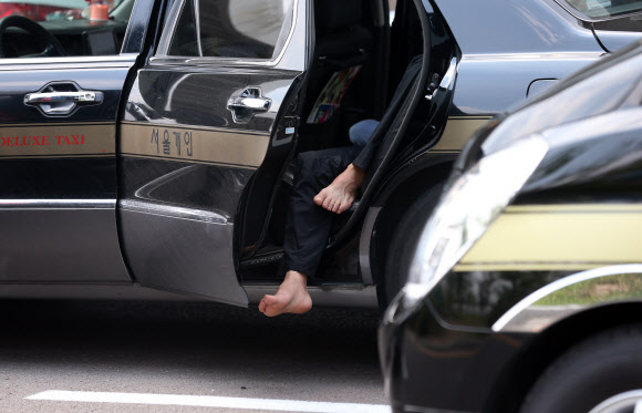 찜통 더위가 기승을 부린 15일 오후 서울 김포공항 택시승강장 앞에서 대기 중인 기사들이 차 문을 연 채 휴식을 취하고 있다. 연합뉴스