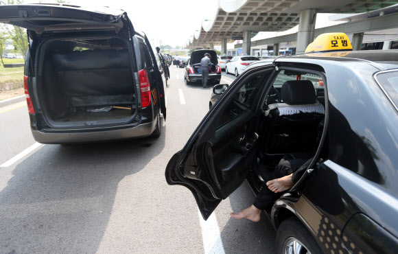 찜통 더위가 기승을 부린 15일 오후 서울 김포공항 택시승강장 앞에서 대기 중인 기사들이 차 문을 연 채 휴식을 취하고 있다. 연합뉴스
