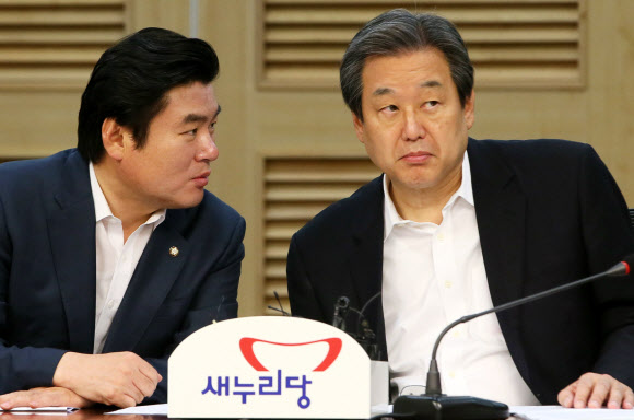 새누리당 김무성 대표(오른쪽)와 원유철 원내대표가 17일 국회 의원회관에서 열린 주요당직자회의에서 대화하고 있다.  연합뉴스