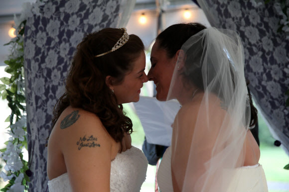 11일(현지시간) 사우스캐롤라이나주 컬럼비아에서 메건 마틴(30·왼쪽)과 멜리사 아담스(32)가 결혼식에서 키스를 하고 있다. 게이 결혼은 2014년 11월 합법화 되었다. 이것은 미국 대법원 결정보다 6개월 앞선 것이다.  ⓒ AFPBBNews=News1