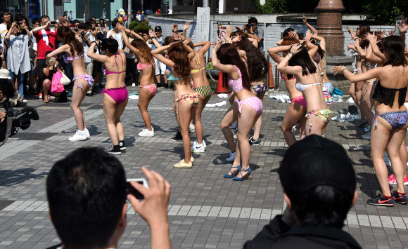 비키니를 입은 30여명의 댄서들이 20일 일본 도쿄 거리에서 플래시몹을 선보이며 춤을 추고 있다. 댄서들은 새로운 수영복을 선보이는 이벤트로 이번 공연을 준비했다. ⓒ AFPBBNews=News1