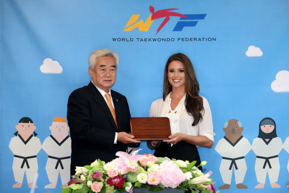 27일 오전 서울 종로구 효자로 세계태권도연맹 서울본부에서 홍보대사 위촉식이 열렸다. 이날 홍보대사로 임명된 2014년 미스 USA 니아 산체스(오른쪽)가 조정원 세계태권도연맹 총재에게 위촉패를 받고 있다. 태권도 4단인 산체스는 네바다주에서는 처음이자 히스패닉으로는 역대 네 번째로 지난해 미스 USA에 뽑혔다. 연합뉴스