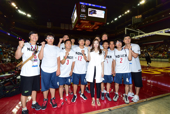 ‘피겨 여왕’ 김연아가 지난 26일(현지시간) ‘2015 하계 스페셜 올림픽’ 농구 경기가 열린 미국 로스앤젤레스 USC 갤런 센터를 방문, 한국 선수들을 격려한 후 기념촬영을 하고 있다.  스페셜올림픽 국제본부 제공