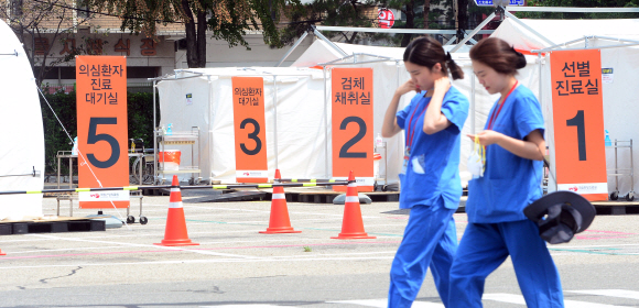 정부가 메르스 종식을 선언한 28일 서울 중구 국립중앙의료원 간호사들이 텅 빈 메르스 의심 환자 선별진료소 앞을 지나가고 있다.  정연호 기자 tpgod@seoul.co.kr