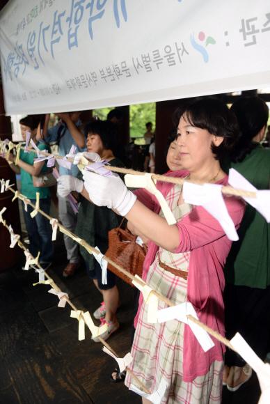 대학수학능력시험 100일을 앞둔 4일 서울 보신각에서 열린 ‘대학 합격기원 타종행사’에 참여한 수험생과 수험생 가족들이 소원을 적은 쪽지를 매달고 있다.  정연호 기자 tpgod@seoul.co.kr