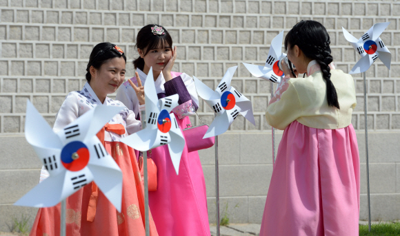 광복 70주년을 맞아 광화문과 청와대 등지에 바람개비형 태극기가 설치된 5일 한복을 입은 학생들이 기념촬영을 하고 있다.  도준석 기자 pado@seoul.co.kr