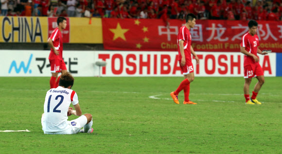 남자축구 대표팀 김승대(왼쪽 아래)가 9일 중국 우한 스포츠센터에서 벌어진 북한과의 동아시안컵 최종전에서 득점 없이 비겨 자력 우승이 물 건너가자 허탈한 모습으로 그라운드에 앉아 있다. 그러나 이어진 경기에서 일본이 중국과 1-1로 비긴 덕에 한국 남자축구는 7년 만에 대회 정상에 복귀했다. 우한 연합뉴스