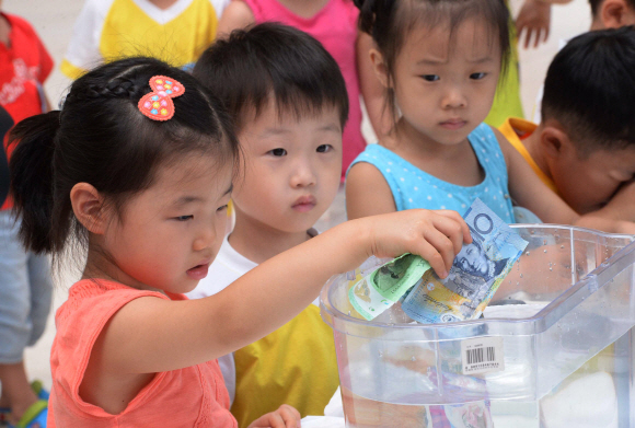 10일 서울 서초구청에서 열린 ’서초구, 제6회 세계화폐 전시회’에서 어린이들이 물에 젖지 않는 지폐를 체험하고 있다.올해로 6회째를 맞는 이 전시회는 ’화폐 속 세계 문화 유산을 찾아서’라는 주제로 15일까지 열린다. 이언탁 기자 utl@seoul.co.kr