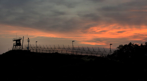 강원도 철원군 중부전선 비무장지대(DMZ)에서 철책 너머로 해가 지고 있다.  연합뉴스