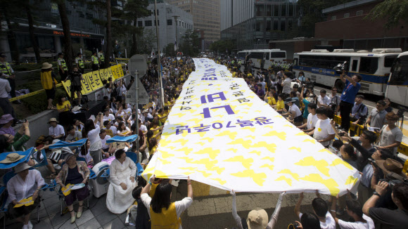 12일 오후 서울 종로구 옛 일본대사관 앞에서 열린 ‘제3차 세계일본군 위안부 기림일 세계연대집회 및 제 1191차 일본군 위안부 문제해결을 위한 정기수요시위’에서 참가자들이 일본 정부의 사죄를 촉구하는 내용이 적힌 대형 현수막을 펼치고 있다.   연합뉴스