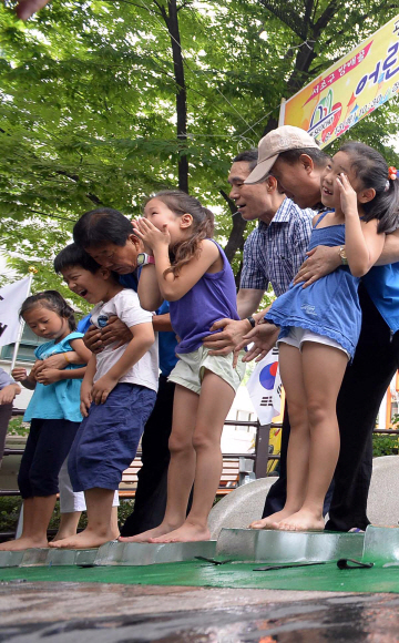 13일 서울시 서초구 뒷벌어린이공원에서 방배골 여름 축제 ’어린이 얼음 위 오래 서있기’ 대회가 열리자 참가 어린이들이 얼음 위에 올라서며 대회를 즐기고 있다.  이언탁 기자 utl@seoul.co.kr