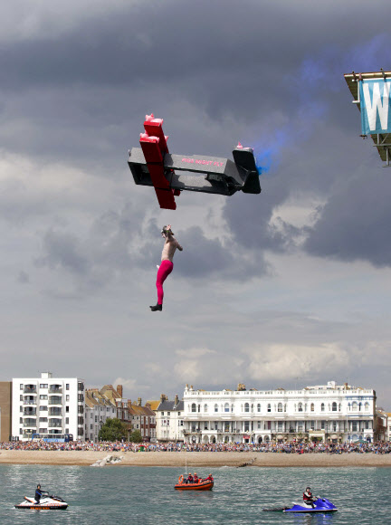 16일(현지시간) 영국 웨스트 서식스에서 열린 ‘국제 버드맨 대회’에 개성 넘치는 의상을 입은 참가자들이 다이빙대에서 뛰어내리고 있다. 이 대회는 비행 기록뿐 아니라 익살스러운 포즈와 의상도 점수에 반영된다. ⓒ AFPBBNews=News1