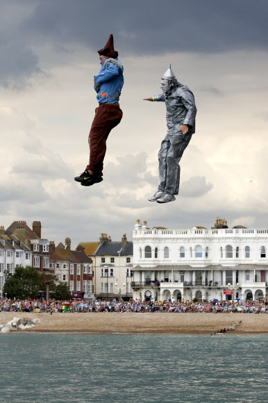 16일(현지시간) 영국 웨스트 서식스에서 열린 ‘국제 버드맨 대회’에 개성 넘치는 의상을 입은 참가자들이 다이빙대에서 뛰어내리고 있다. 이 대회는 비행 기록뿐 아니라 익살스러운 포즈와 의상도 점수에 반영된다. ⓒ AFPBBNews=News1