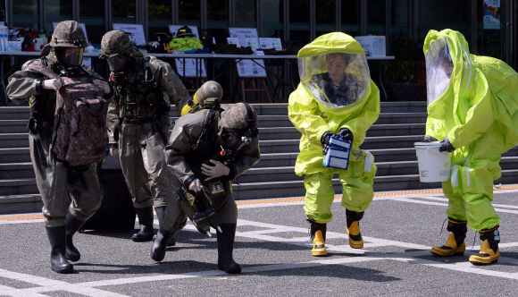최근 중동호흡기증후군 메르스(MERS)로 인하여 많은 피해를 입은 교훈을 바탕으로 생물무기 사고시 대응 조치가 절실하다는 판단에 따라 2015년 을지연습기간인 18일 18일 서울 서초구청 광장에서 민ㆍ관ㆍ군ㆍ경ㆍ소방 통합으로 전시 감염병(페스트, 탄저균 등) 테러에 대비한 훈련을 실시하고 있다. 이번 훈련은 국군화생방방호사령부, 국군화생방방어연구소, 메르스 환자를 호송 전담했던 서초소방서 119구조대, 서초경찰서, 화생방전문병원인 서울성모병원, 보건소 감염병 전담팀 등 전시 감염병 대책 전문 유관기관이 통합하여 최초 신고부터 시료채취, 분석, 역학조사, 제독에 이르는 전 과정을 실제 훈련으로 진행했다. 2015.08.18. 이종원 선임기자 jongwon@seoul.co.kr
