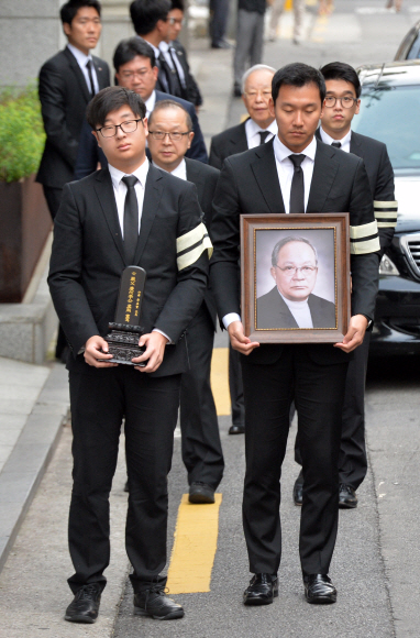 故 이맹희 CJ명예회장의 위패와 영정을 든 유족들이 20일 서울 중구 필동 CJ인재원에 마련된 영결식장으로 들어가고 있다. 위패 든 이는 이 명예회장의 차남인 이재환 재산커뮤니케이션즈 대표의 아들 이호준씨, 영정 든 이는 이재현 CJ회장의 사위 정종환씨. 손형준 기자 boltagoo@seoul.co.kr