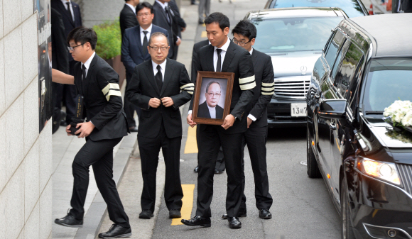 故 이맹희 CJ명예회장의 위패와 영정을 든 유족들이 20일 서울 중구 필동 CJ인재원에 마련된 영결식장으로 들어가고 있다. 위패 든 이는 이 명예회장의 차남인 이재환 재산커뮤니케이션즈 대표의 아들 이호준씨, 영정 든 이는 이재현 CJ회장의 사위 정종환씨.  손형준 기자 boltagoo@seoul.co.kr