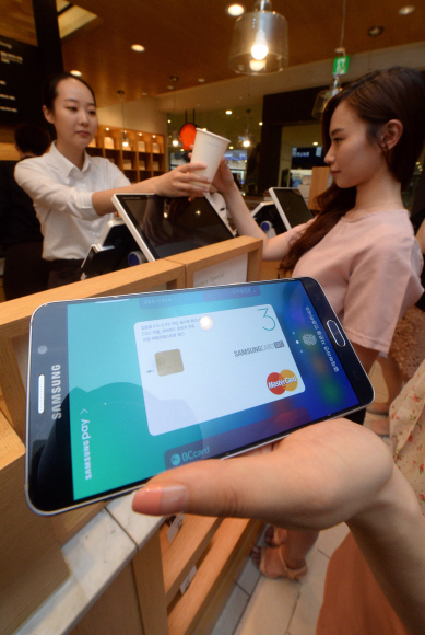 20일 서울 서초구의 한 커피숍에서 한 고객이 이날 출시된 갤럭시 s6 엣지에 설치된 삼성페이로 커피값을 계산하고 있다. 정연호 기자 tpgod@seoul.co.kr