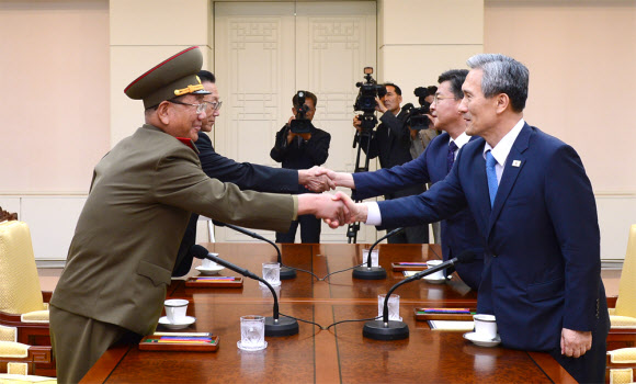 북한의 서부전선 포격도발로 한반도의 긴장이 고조된 가운데 22일 오후 판문점에서 열린 남북 고위급 접촉 시작에 앞서 참석자들이 악수를 하고 있다. (오른쪽부터 시계반대방향)김관진 국가안보 실장, 홍용표 통일부 장관, 김양건 노동당 비서, 황병서 군 총정치국장. 2015.8.22. 통일부 제공