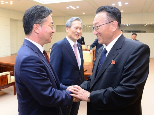 남북 고위급 회담이 합의를 이뤄낸 가운데 홍용표(왼쪽) 통일부 장관과 김양건 북한 노동당 비서가 악수를 나누며 웃고 있다. 통일부 제공