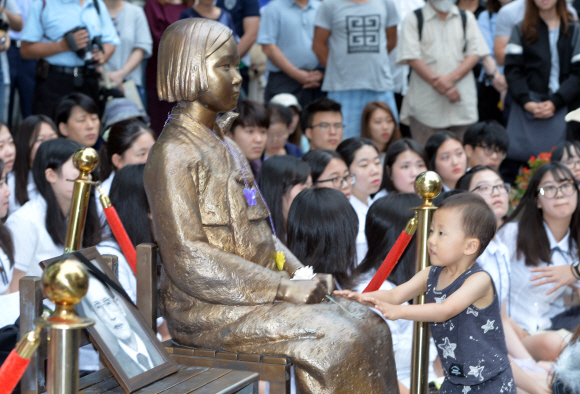26일 서울 일본대사관 앞에서 일본을 규탄하며 분실 자살로 생을 마감한 故최현열선생 추모식에서 한 어인이가 소녀상을 만지고 있다. 2015.8.26 박지환 popocar@seoul.co.kr