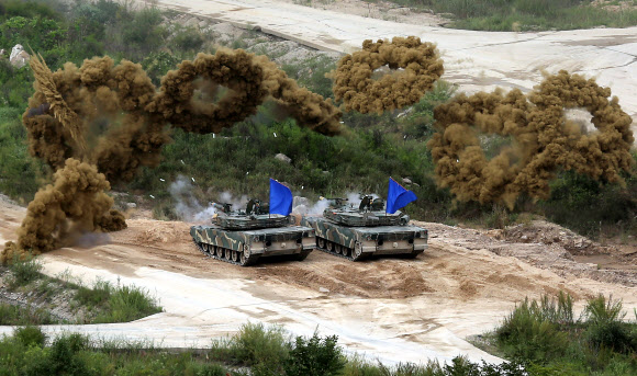 24일 경기도 포천 승진훈련장에서 열린 2015 통합화력 격멸 훈련에서 K1A1 전차들이 연막탄을 터뜨리고 있다. 연합뉴스