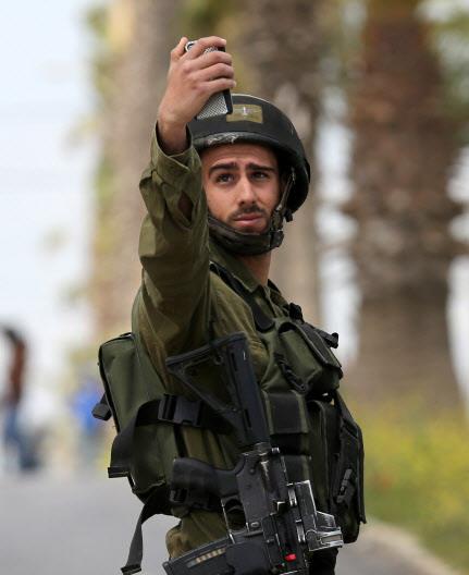 이스라엘군은 우리 돈으로 31만원가량의 월급을 받습니다. 그런데 예비군 훈련비가 하루 10만원이라고 합니다. 휴대전화로 사진을 촬영하는 이스라엘 병사.   AFPBBNews=News1