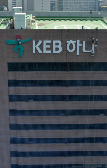 하나은행과 외환은행의 합병으로 탄생하는 KEB하나은행 출범을 하루 앞둔 31일 서울 중구 을지로 외환은행 본점 외벽에 새 간판이 내걸리고 있다. 손형준 기자 boltagoo@seoul.co.kr