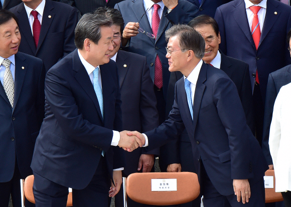 김무성 새누리당 대표와 문재인 새정치민주연합 대표가 1일 국회 정현관 앞 계단에서 열린 국회의원 단체 기념사진 촬영에 앞서 악수를 나누고 있다.  김명국 전문기자 daunso@seoul.co.kr