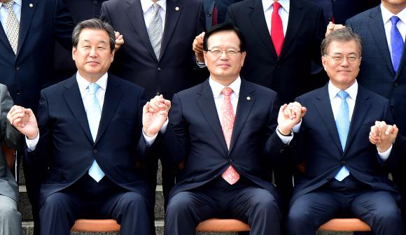 정의화 국회의장과 김무성 새누리당 대표, 문재인 새정치민주연합 대표가 1일 국회 정현관 앞 계단에서 열린 국회의원 단체 기념사진 촬영에서 손을 맞잡고 있다.   김명국 전문기자 daunso@seoul.co.kr