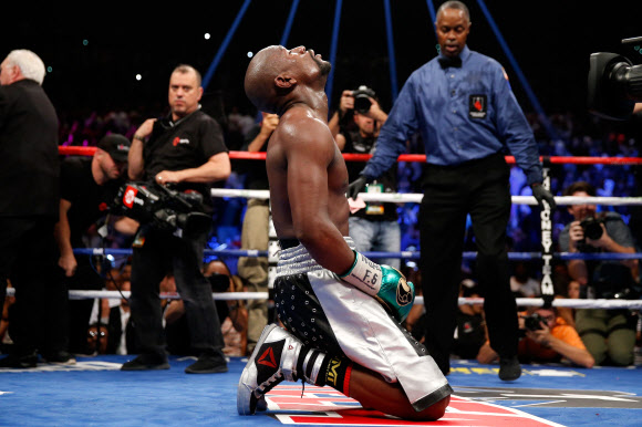 Floyd Mayweather Jr. kneels on the mat after winning his WBC/WBA welterweight title fight against Andre Berto at MGM Grand Garden Arena on September 12, 2015 in Las Vegas, Nevada. Mayweather won the fight by unanimous decision.    