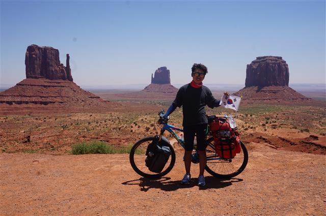 자전거로 미국 횡단 중 천병탁씨가 애리조나 사막의 모뉴먼트 밸리에서 포즈를 취하고 있다.