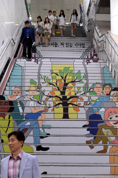 15일 서울 지하철 5호선 광화문역에 ‘독서를 권하는 계단’이 조성되자 시민들이 계단을 오르내리고 있다. 서울도시철도공사는 ‘테마계단 조성사업’ 일환으로 서울도서관, 교보문고와 업무협약을 체결하고 광화문역 계단에 독서와 관련된 다양한 이미지를 래핑해 독서를 권하는 지속적인 홍보를 이어나간다고 밝혔다 2015.9.15 이언탁 utl@seoul.co.kr